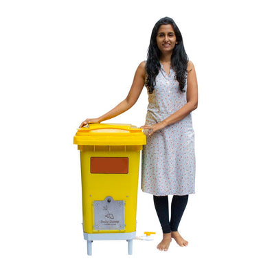 Lady standing next to kitchen waste in Daily Dump Gobble Mini home composter